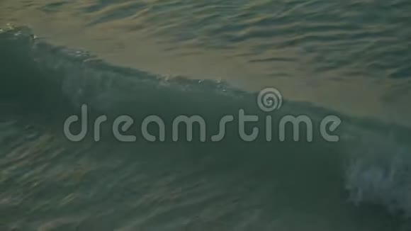 夕阳下沙滩上海浪翻滚视频的预览图