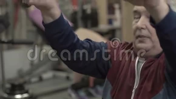 一位在健身房和教练一起工作的老人视频的预览图