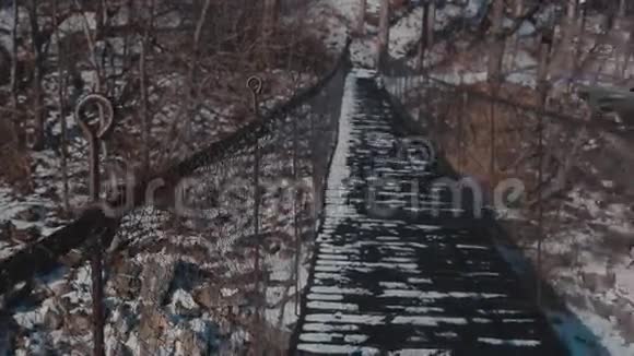 冬天的木桥冬季河流的悬索桥视频的预览图
