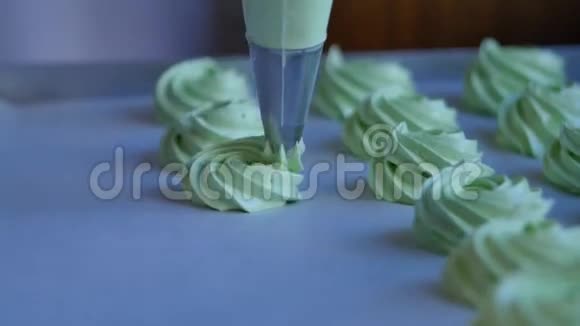 把奶油馅挤在绿色纸杯蛋糕上特写视频的预览图