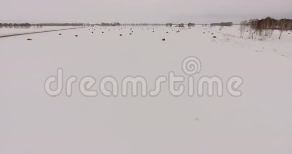 西伯利亚空中一条僻静的道路一片有干草堆的雪地视频的预览图