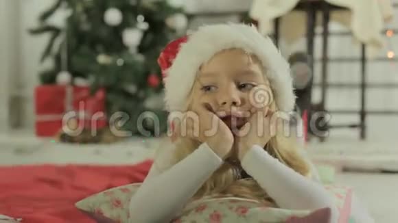 戴着圣诞老人帽子的可爱小女孩躺在视频的预览图