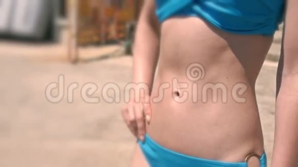 穿比基尼在海滩附近的年轻女运动员靠近腹部肌肉视频的预览图