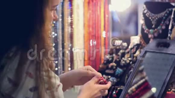 一位年轻女子在市场上试穿手镯视频的预览图