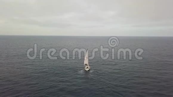 空中观景豪华帆船在蔚蓝的大海中在天边的阴云中航行视频的预览图