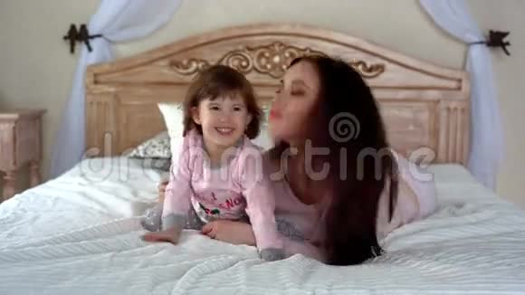 快乐的年轻母女在床上拥抱视频的预览图