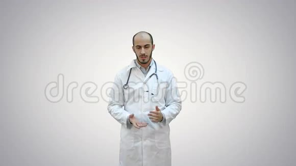 严肃的男医生在白色背景上和摄像机说话视频的预览图
