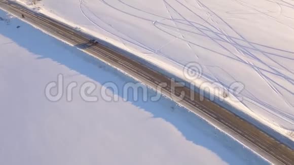 鸟瞰雪域和道路在冻土带的路上的车俯视视频的预览图