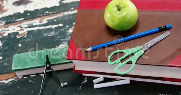 带学习用品的书堆上的绿苹果视频的预览图