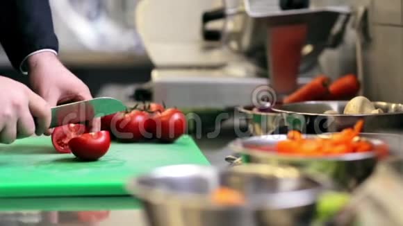 男厨师在厨房切西红柿视频的预览图
