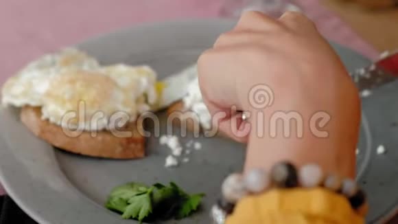 一位美丽的年轻女士在咖啡馆里用烤面包和鸡蛋吃早餐视频的预览图