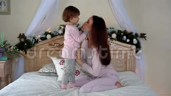 快乐的年轻母女在床上拥抱视频的预览图
