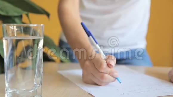 年轻女子在一张堆满书的桌子上写字和做作业视频的预览图