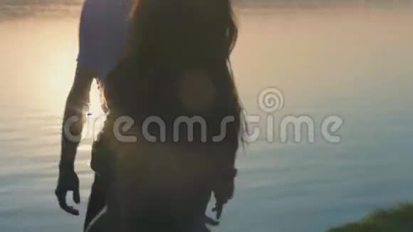 日落时分一对年轻夫妇在沙滩上奔跑视频的预览图
