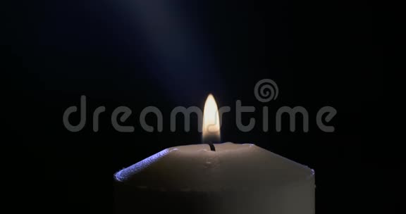 一支蜡烛在黑暗的背景上发出的宏光视频的预览图