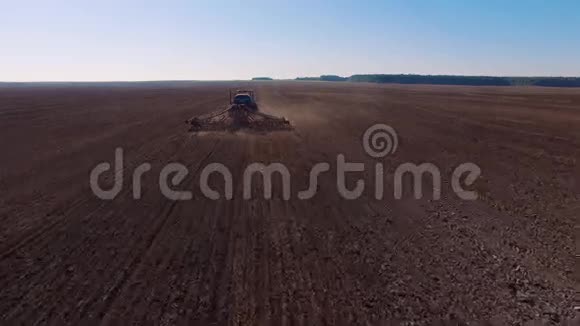 一辆现代拖拉机在干田里犁地准备播种的4k空中镜头视频的预览图