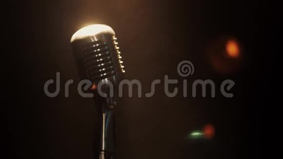 在明亮的聚光灯下音乐会老式麦克风的视野停留在舞台上抽烟视频的预览图