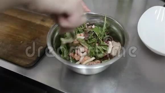厨师用海鲜搅拌蔬菜沙拉厨师用海鲜做蔬菜沙拉厨师手工烹饪和烹饪的特写视频的预览图