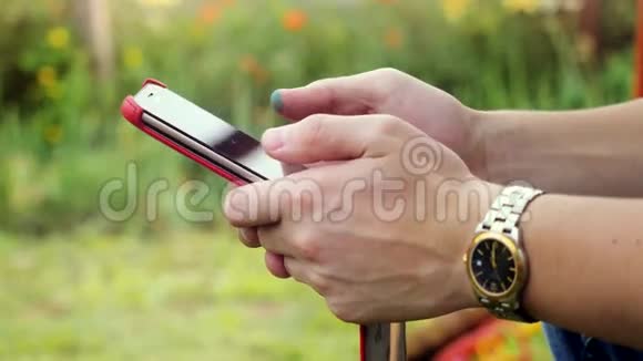 在公园里使用智能手机打字的商人戴着智能手表在户外3840x2160视频的预览图