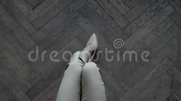 修长纤细的双腿穿着米色时尚高跟鞋女性腿在木制镶木背景视频的预览图