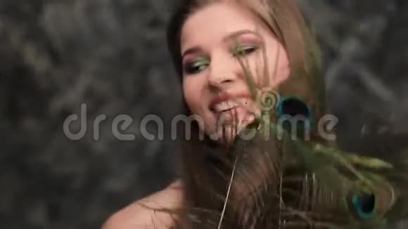 少女孔雀羽毛和美丽的微笑视频的预览图