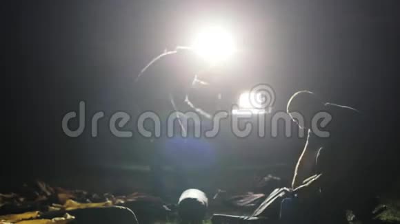 两名男子从远征军越野车上在ligh搭建帐篷的夜间镜头视频的预览图