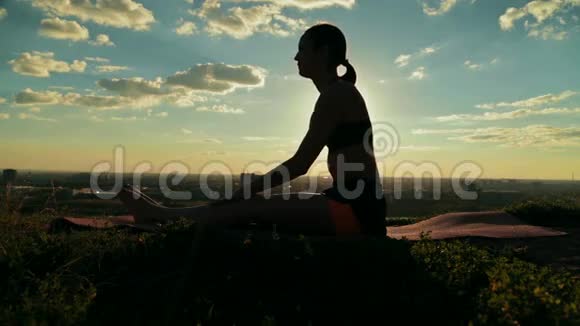 日落时分在森林里做阿斯汤加瑜伽的女人视频的预览图