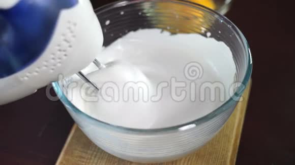用电动搅拌器搅拌奶油在玻璃碗中加入蛋黄视频的预览图