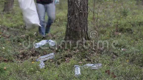 在森林里拿旧塑料瓶的人视频的预览图