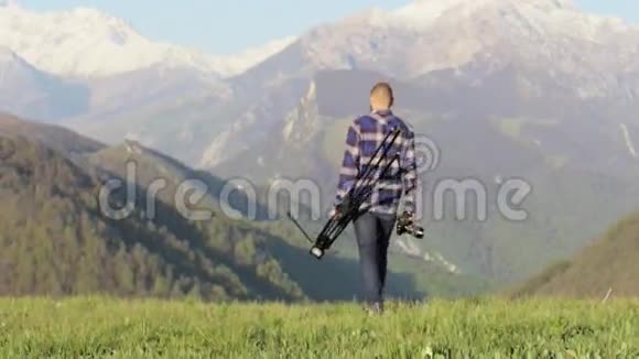 野生动物自然摄影师与三脚架步行在山景视频的预览图