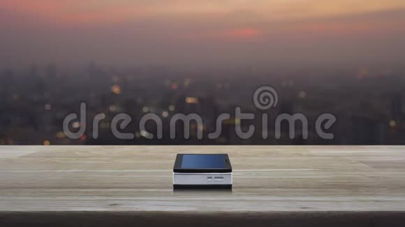 木桌上现代智能手机屏幕上的信息标志平面图标在暖光日落时城市景观模糊Busin视频的预览图