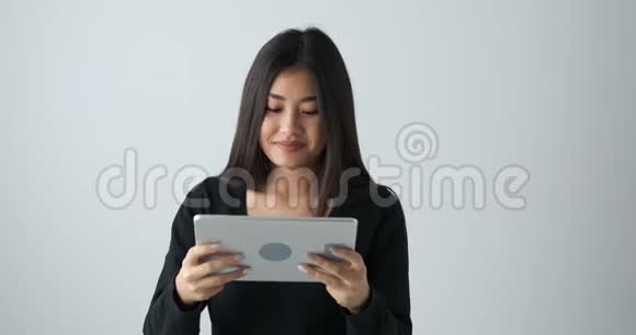 快乐的女人在玩数字平板电脑游戏视频的预览图