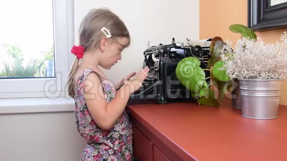 可爱的小女孩在老式打字机上写字学前观念童年观念像学龄前儿童这样可爱的女孩视频的预览图