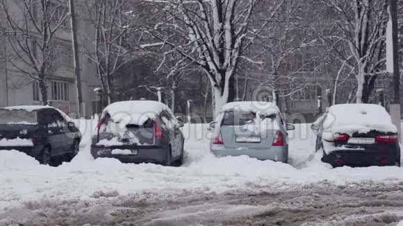 积雪覆盖的汽车停在暴风雪中视频的预览图