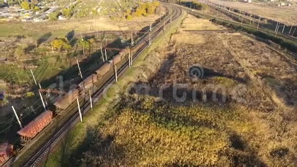 从空中俯瞰一列满载煤炭的货运列车无人驾驶的飞机越过横跨河流的货运列车视频的预览图