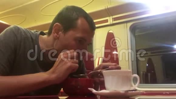男人晚上在火车餐厅吃汤铁路猫喝咖啡的生活方式火车上的人概念之旅视频的预览图