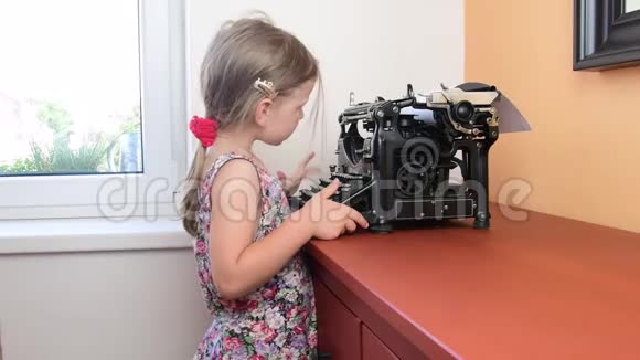 可爱的小女孩在老式打字机上写字学前观念童年观念像学龄前儿童这样可爱的女孩视频的预览图
