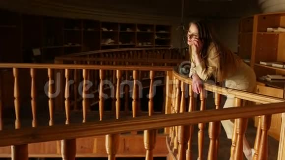 漂亮的年轻商务女性摘下眼镜旧的老式图书馆背景视频的预览图