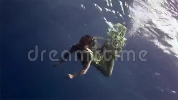 在红海珊瑚的背景下身穿仙女服装的水下潜水员模型视频的预览图