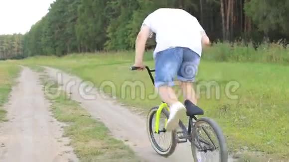 夏天年轻人骑自行车在大街上阳光明媚的公园里视频的预览图