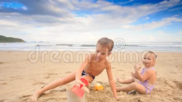 小女孩小男孩甘宝在沙滩上玩湿沙视频的预览图