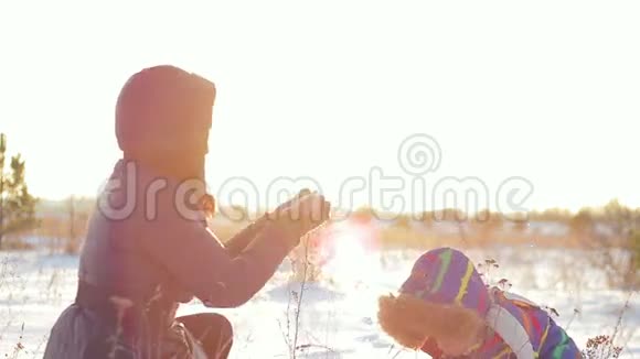 快乐的女人和孩子在日落时玩雪视频的预览图