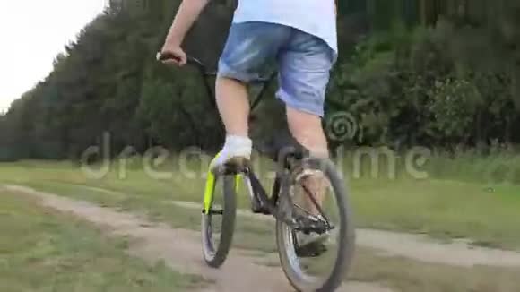 夏天年轻人骑自行车在大街上阳光明媚的公园里视频的预览图