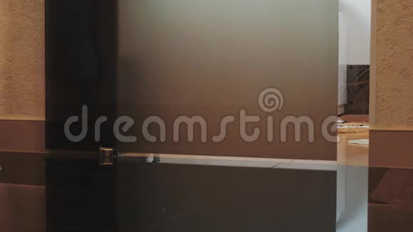 穿着浴袍的女人来到浴室打开门坐在白色的浴室里视频的预览图