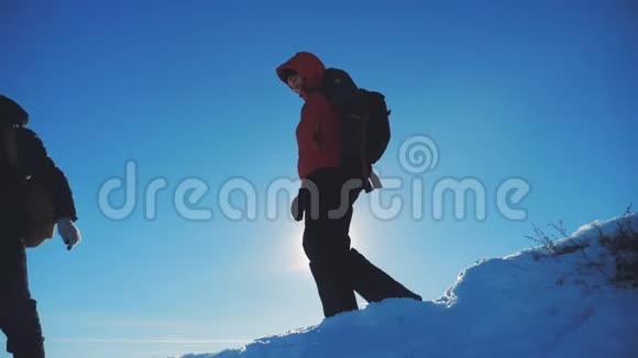 男子旅行者在冬季登山剪影阳光慢动作视频旅行冒险生活方式冬天视频的预览图