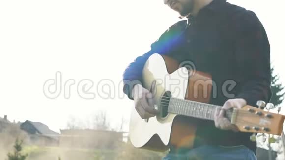 在户外弹吉他的人用吉他演奏音乐视频的预览图