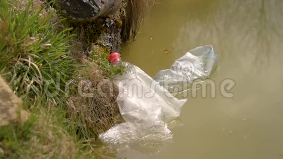 塑料在水中的污染塑料废物在水中漂浮环境保护塑料瓶和瓦上的其他垃圾视频的预览图