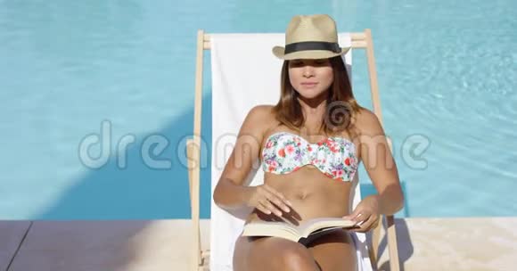 戴着时髦帽子在阳光下放松的年轻女子视频的预览图