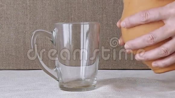 女人把牛奶从水罐里倒入玻璃杯里视频的预览图