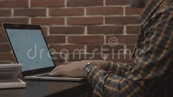 穿格子衬衫的人在笔记本电脑上工作视频的预览图